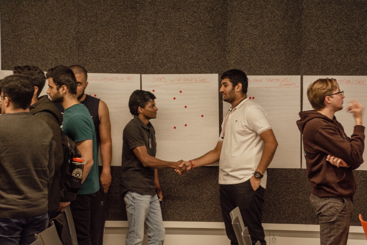 Two students shake hands at startup weekend
