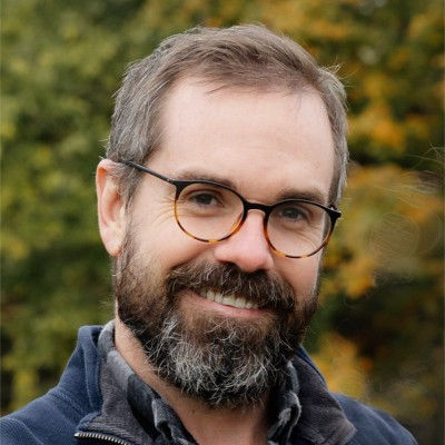 professional headshot of tom wearing glasses