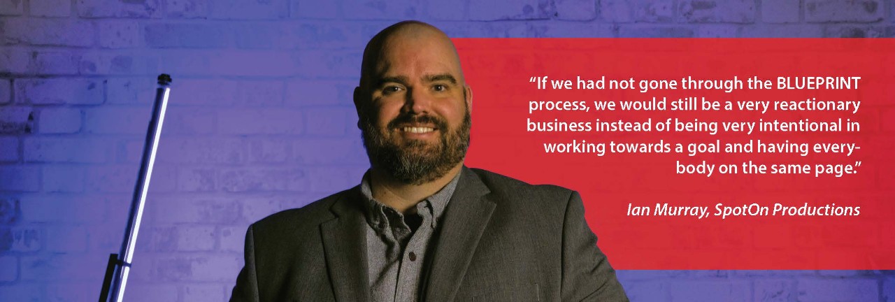 Molly Fender of Monti Incorporated, posing in front of art at her family's business.