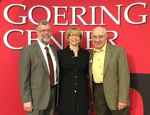 Alan Beaulieu (left), Carol Butler (center), and John Goering (right) pose in front of a Goering Center backdrop