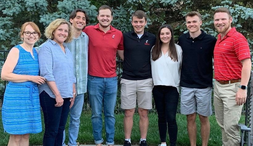 A pair of Lindner faculty pose for a photo with students.