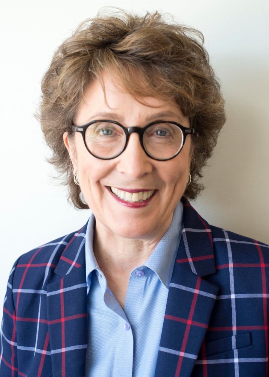 A woman wears a blue jacket and a blue shirt.