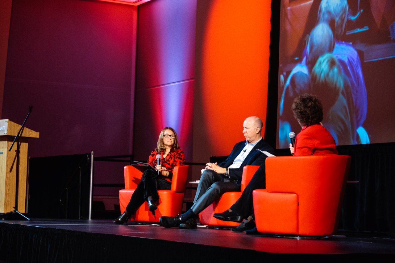 Two women and a man speak on a panel.