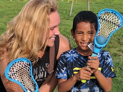 Katelyn Jarvis, left, and a Honduran boy, holding lacrosse sticks