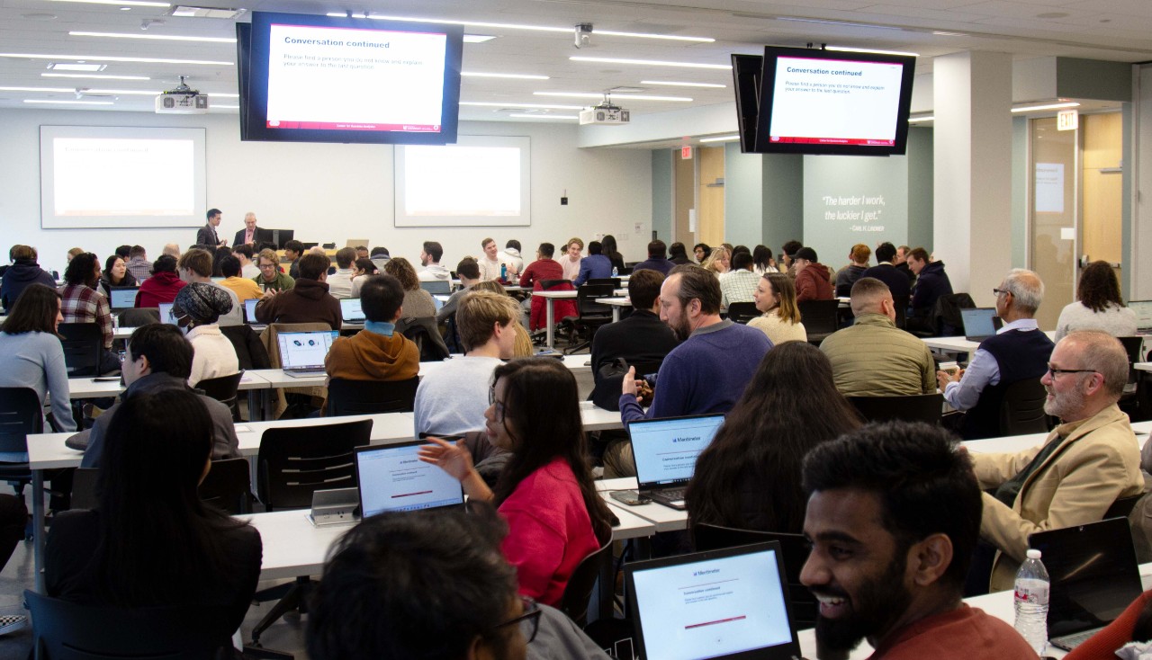 Students and Center for Business Analytics stakeholders chat in a classroom.