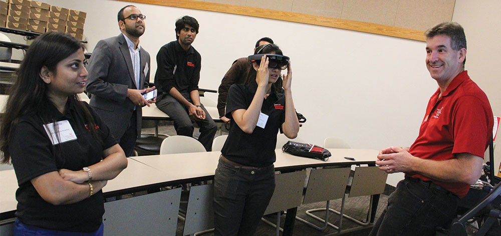 Professor Dave Rapien demonstrates the Microsoft HoloLens to a group of Lindner graduate students.