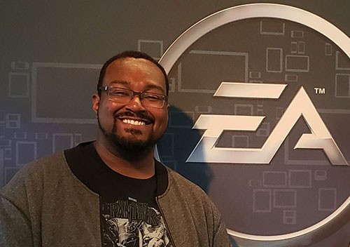 John Thomas poses in front of an EA logo at the company's headquarters