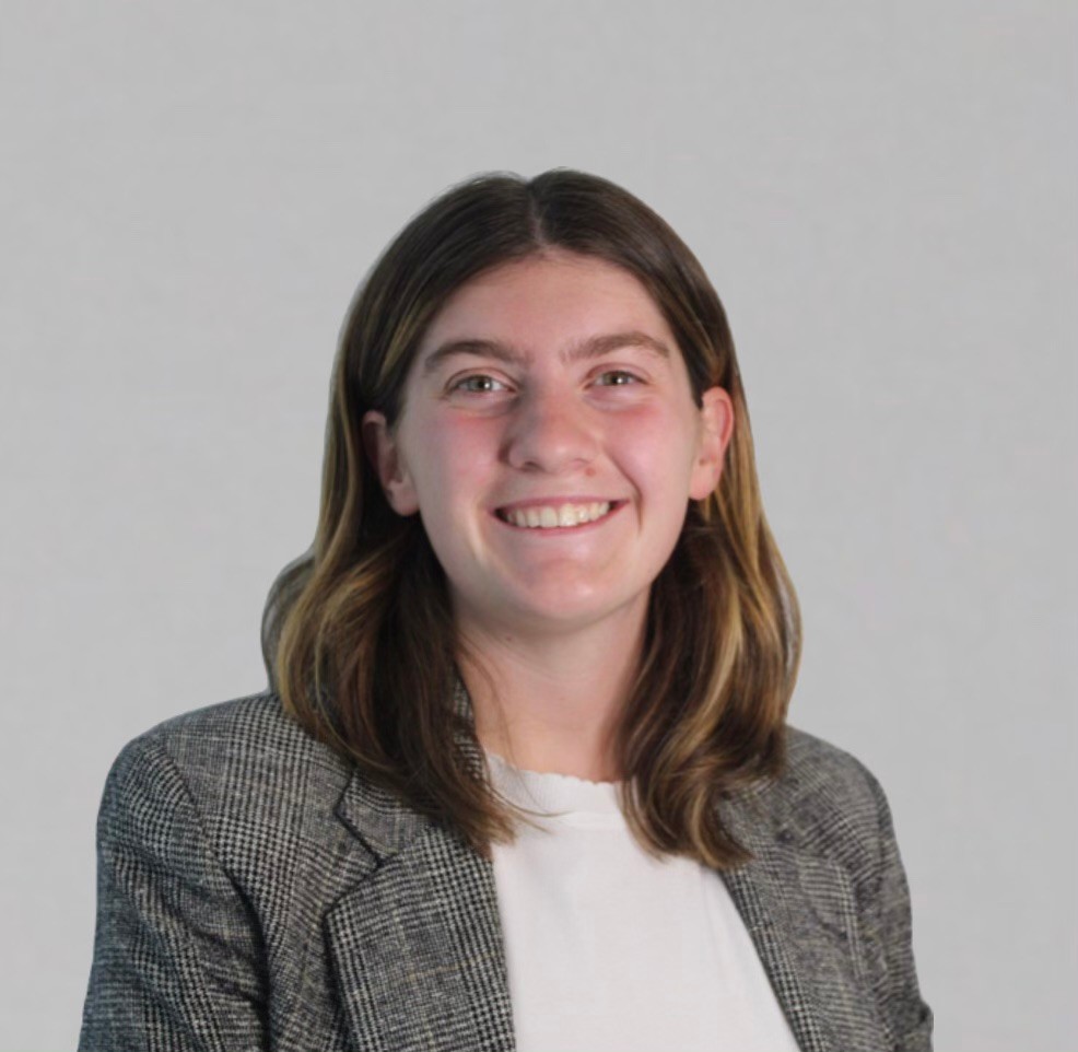 Mia Shaffer wears a gray jacket over a white shirt.