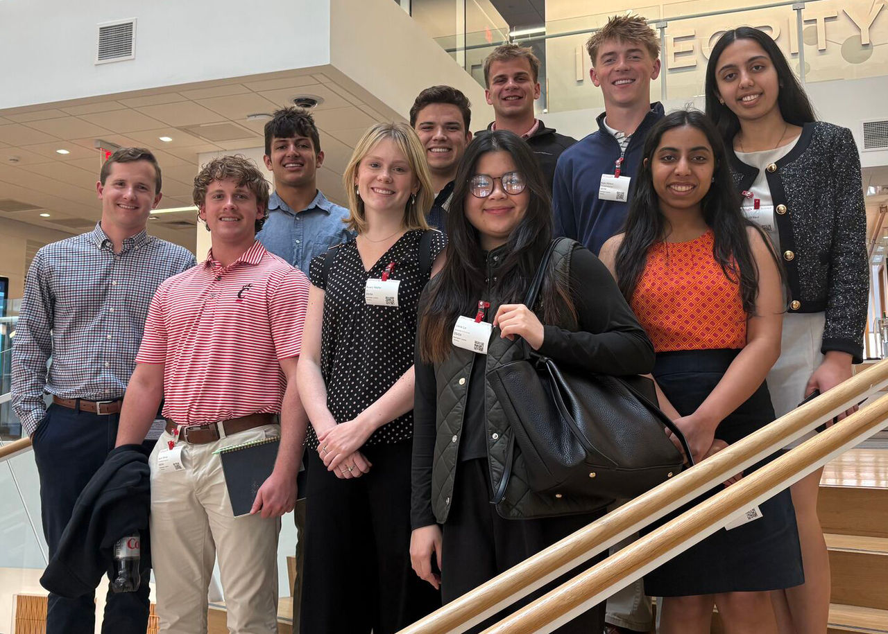 Students pose for a picture on steps during a company visit.